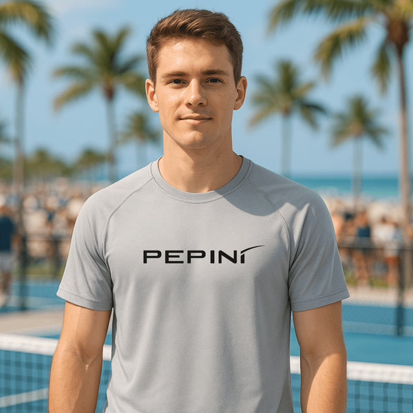 Man wearing a gray t-shirt with 'PEPINI' logo at a poolside with palm trees in the background