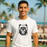 Man wearing a white t-shirt with a black bulldog graphic on a beach background