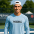 Man wearing a light blue pickleball shirt on a tennis court