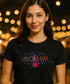Woman wearing a black t-shirt with 'Pickleball' design against a blurred bokeh background
