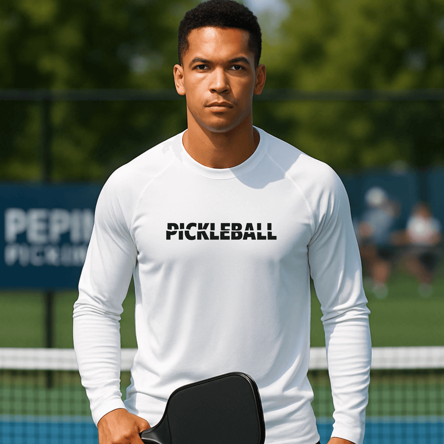 Man wearing a white 'Pickleball' shirt on a pickleball court